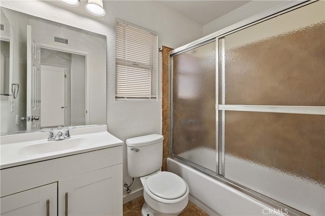 full bathroom with toilet, bath / shower combo with glass door, and vanity