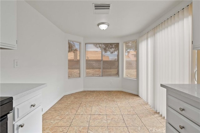 unfurnished dining area featuring light tile patterned floors