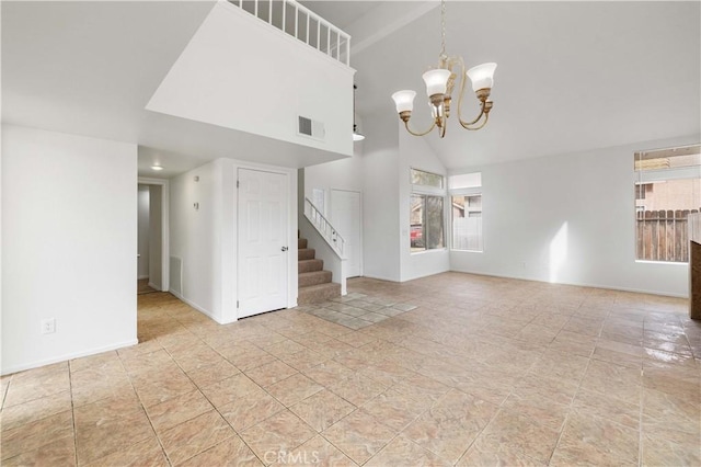 unfurnished living room with a chandelier and high vaulted ceiling