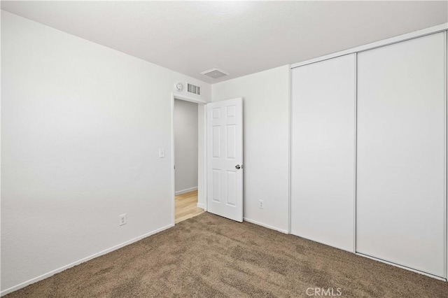 unfurnished bedroom featuring a closet and carpet flooring