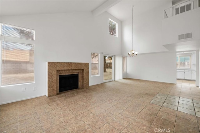 unfurnished living room featuring a fireplace, beam ceiling, an inviting chandelier, high vaulted ceiling, and light tile patterned floors