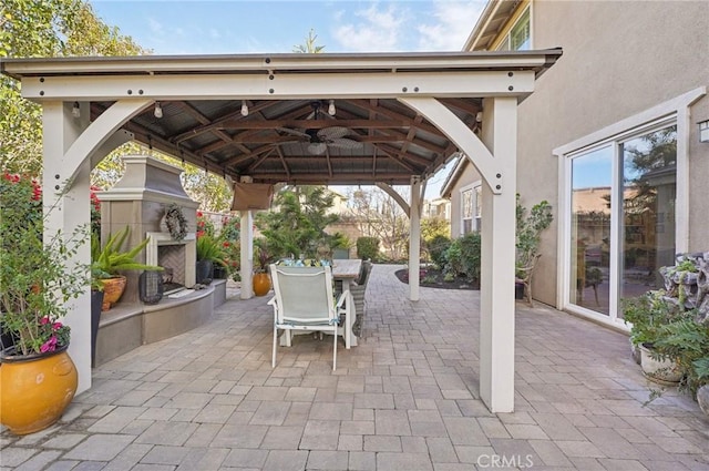 view of patio with a gazebo and a tiled fireplace