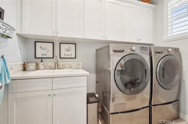 laundry area featuring washer and clothes dryer, sink, and cabinets