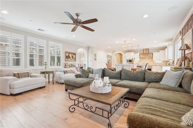 living room featuring ceiling fan, light hardwood / wood-style flooring, and ornamental molding