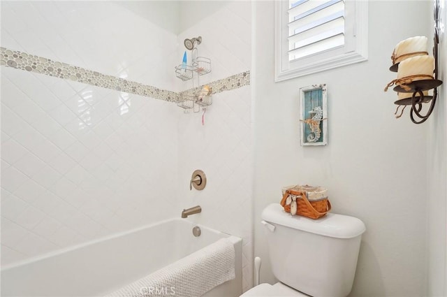 bathroom featuring toilet and tiled shower / bath combo