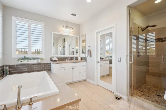 bathroom featuring tile patterned flooring, vanity, and shower with separate bathtub