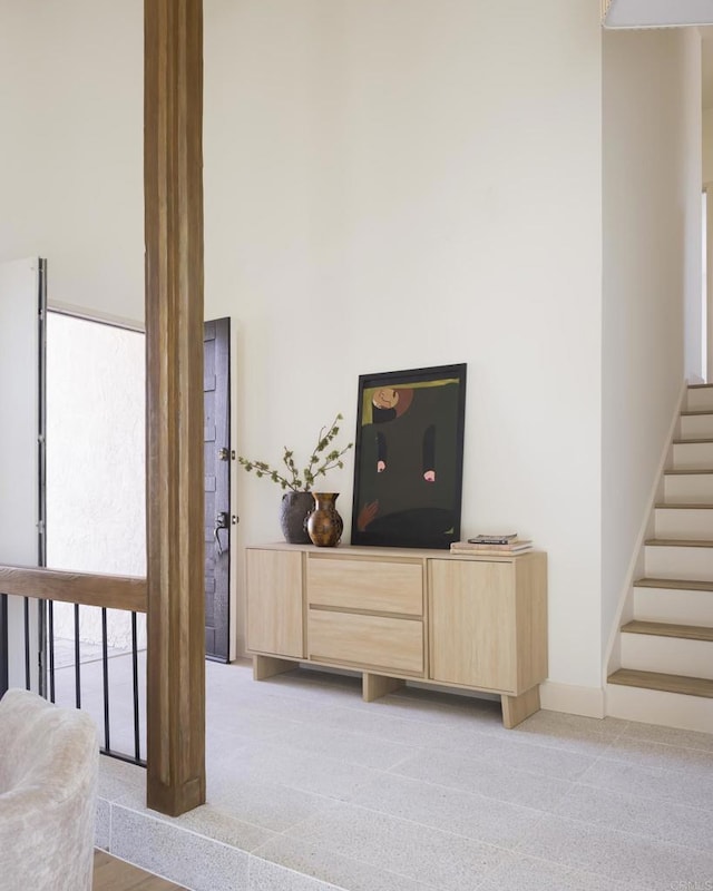 living room with light colored carpet, baseboards, and stairs