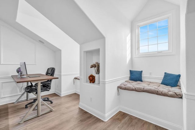 home office with vaulted ceiling and light hardwood / wood-style floors