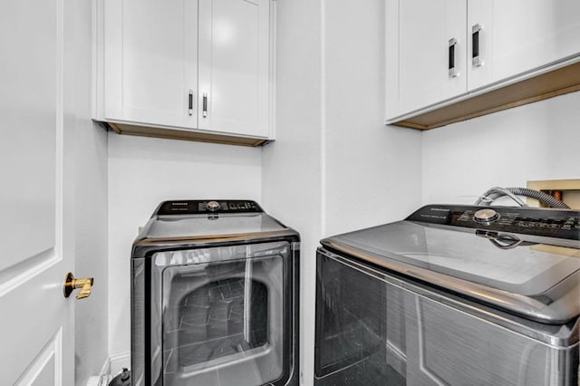 clothes washing area with independent washer and dryer and cabinets