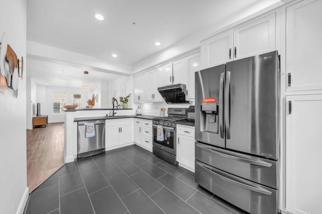 kitchen with kitchen peninsula, sink, hanging light fixtures, stainless steel appliances, and white cabinets