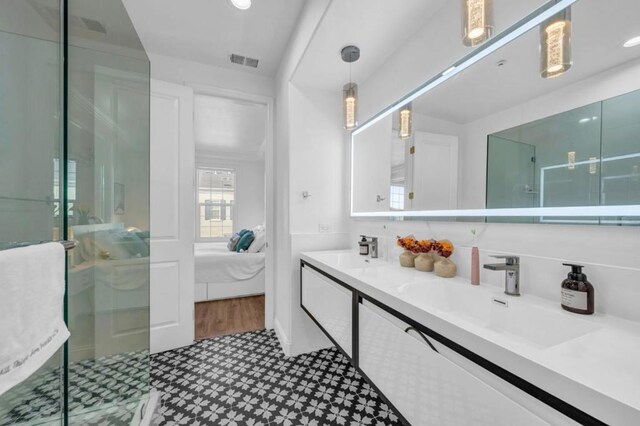 bathroom with vanity and a shower with door