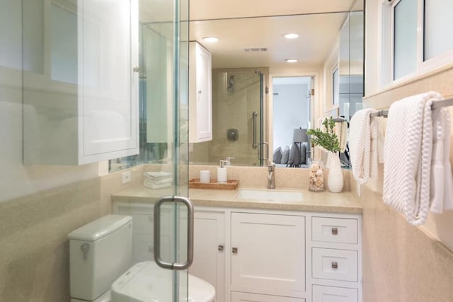 bathroom featuring vanity, toilet, and walk in shower