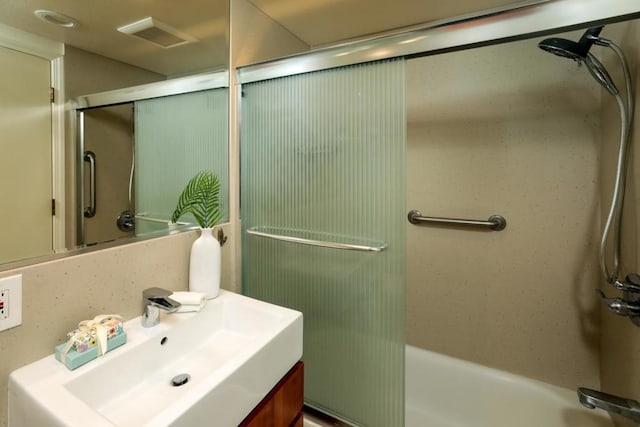 bathroom with vanity and bath / shower combo with glass door