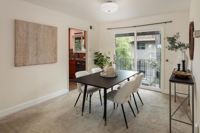 carpeted dining area featuring sink