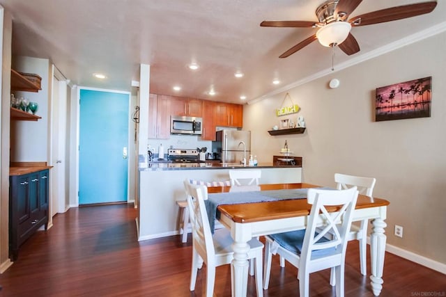 dining room with ceiling fan, sink, dark hardwood / wood-style floors, and ornamental molding