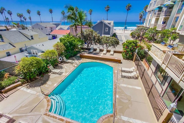 view of swimming pool featuring a patio area and a water view