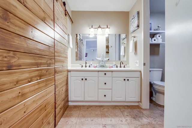 bathroom featuring toilet, tile patterned flooring, wooden walls, and vanity