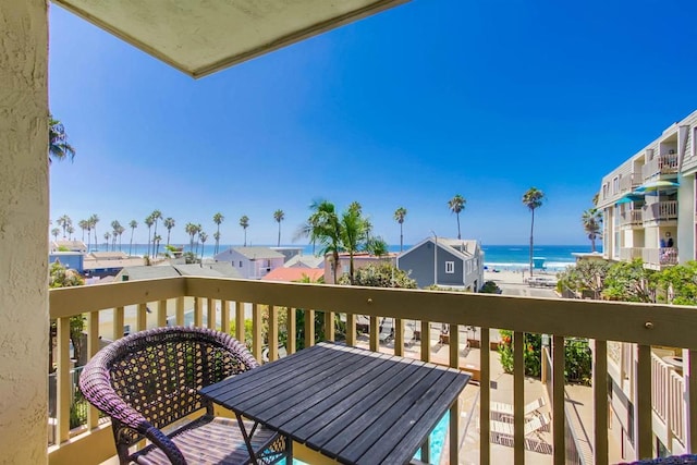 balcony featuring a water view and a beach view