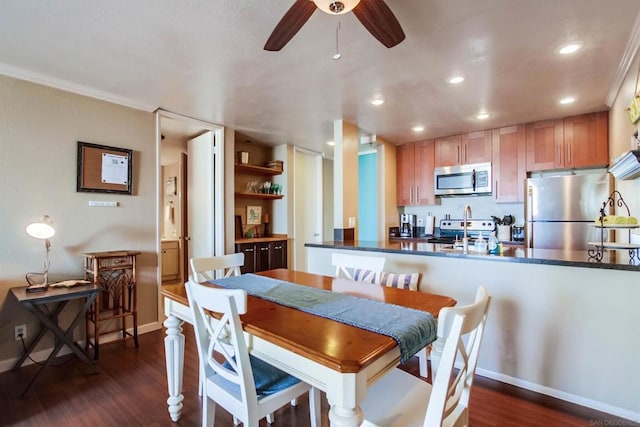 dining area featuring ceiling fan, dark wood-type flooring, and ornamental molding