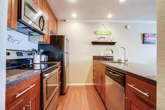 kitchen featuring dark stone countertops, sink, light hardwood / wood-style flooring, appliances with stainless steel finishes, and ornamental molding