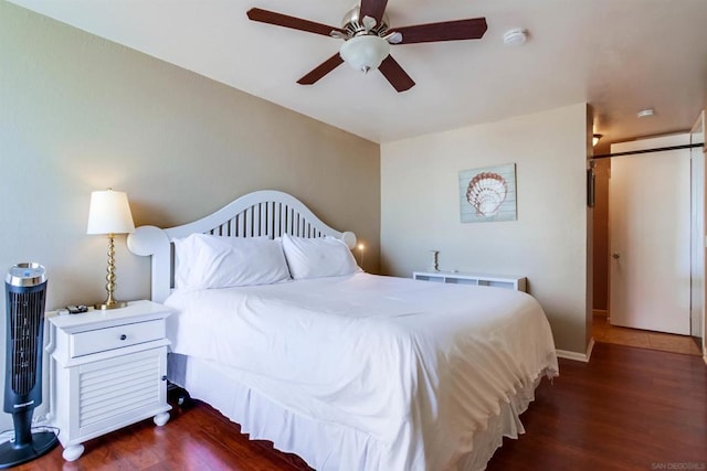 bedroom with ceiling fan and dark hardwood / wood-style flooring