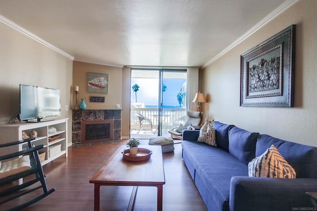 living room with dark hardwood / wood-style floors, a tile fireplace, crown molding, and floor to ceiling windows