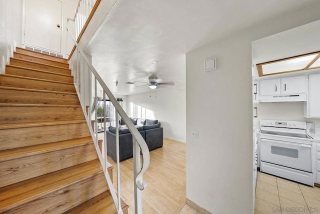 stairway with ceiling fan and tile patterned floors