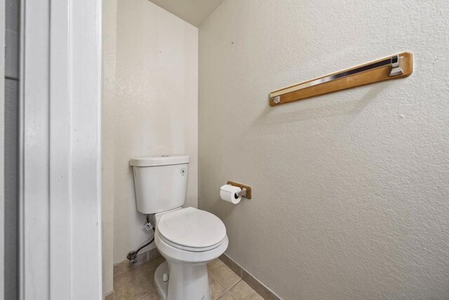 bathroom with toilet and tile patterned floors