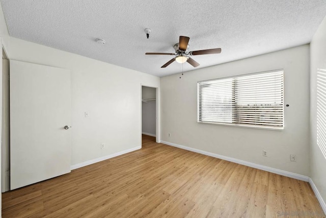 unfurnished bedroom with ceiling fan, a closet, a textured ceiling, and light hardwood / wood-style floors