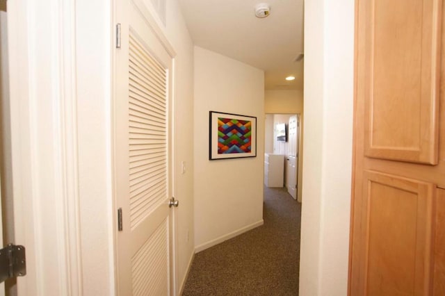 hall with dark colored carpet