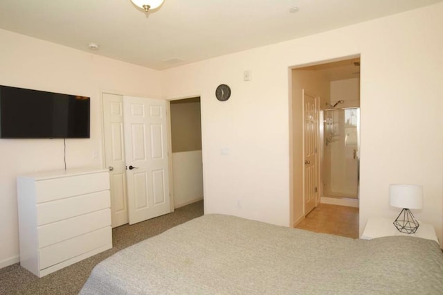 carpeted bedroom with a closet and ensuite bathroom