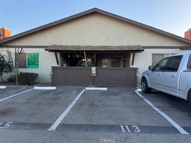 exterior space featuring stucco siding and uncovered parking