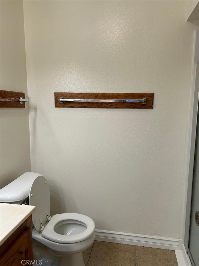 bathroom with toilet, tile patterned floors, vanity, and baseboards