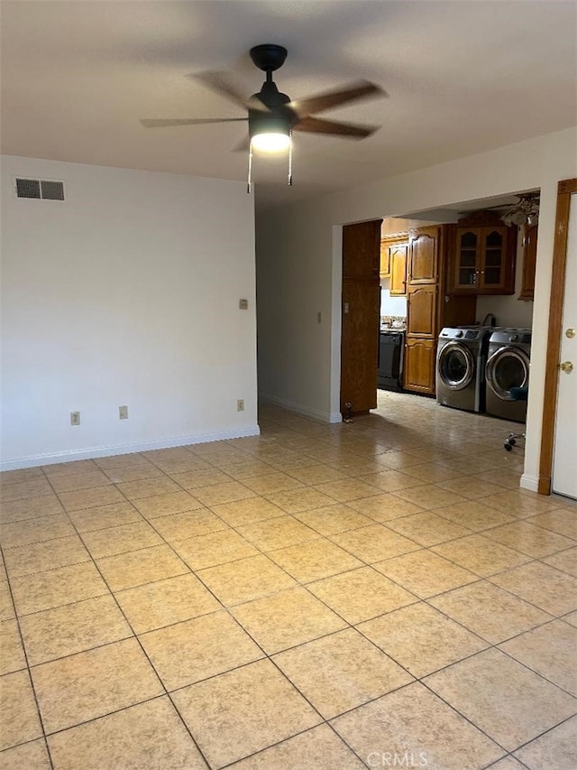 spare room with baseboards, washing machine and dryer, visible vents, and ceiling fan