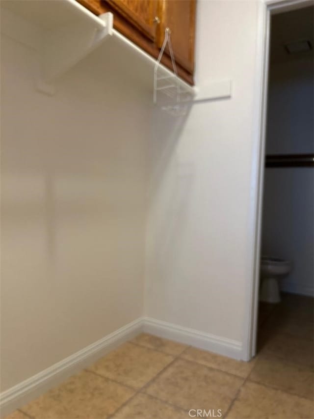 spacious closet with light tile patterned floors