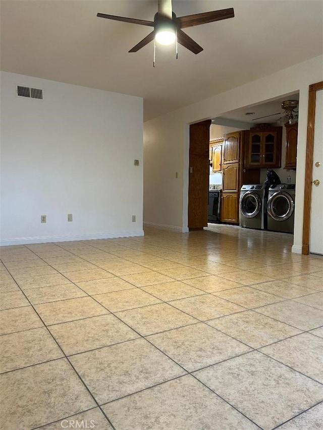 spare room with visible vents, washer and clothes dryer, a ceiling fan, and baseboards