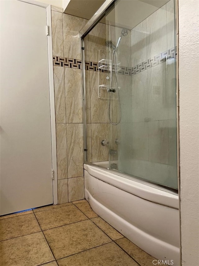 bathroom with combined bath / shower with glass door and tile patterned flooring