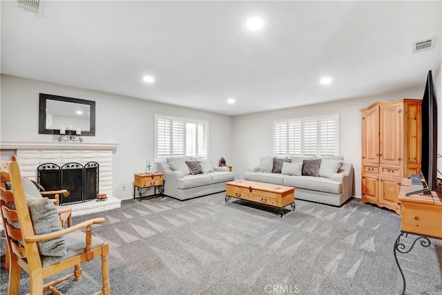 carpeted living room with a brick fireplace