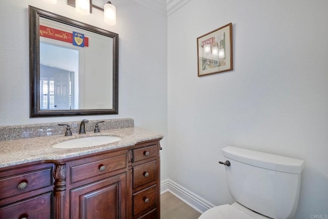 bathroom featuring crown molding, vanity, and toilet