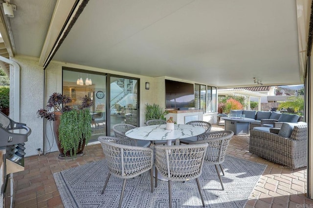 view of patio with an outdoor living space with a fire pit