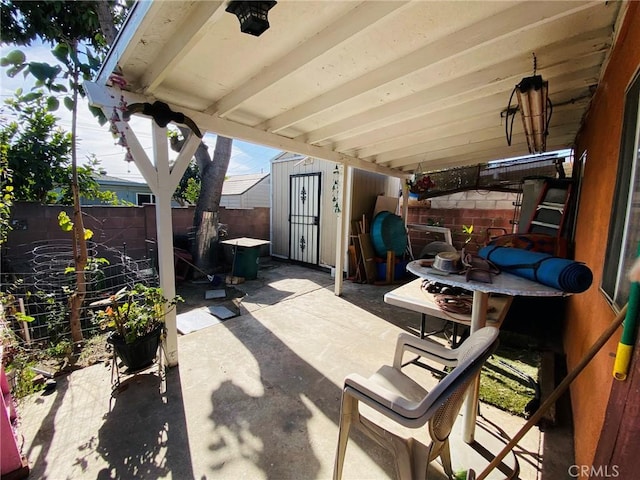 view of patio / terrace featuring an outbuilding, a shed, and a fenced backyard