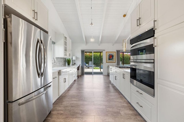 kitchen featuring beam ceiling, decorative light fixtures, white cabinets, and stainless steel appliances