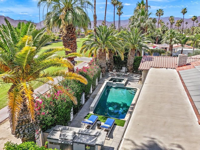 view of swimming pool with a mountain view and a patio area