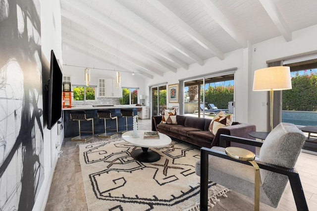 living room with beam ceiling, plenty of natural light, and light hardwood / wood-style floors