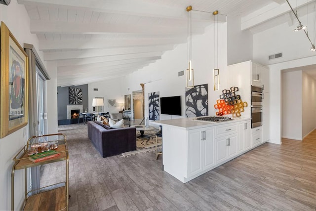 kitchen with a kitchen bar, white cabinetry, light hardwood / wood-style flooring, and kitchen peninsula