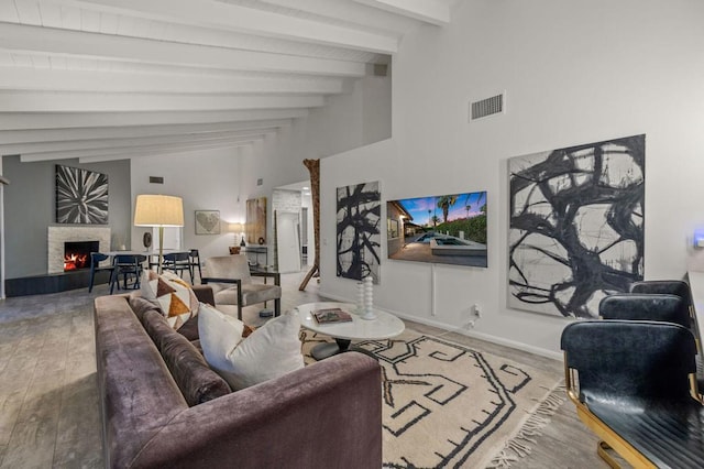 living room featuring vaulted ceiling with beams and wood-type flooring