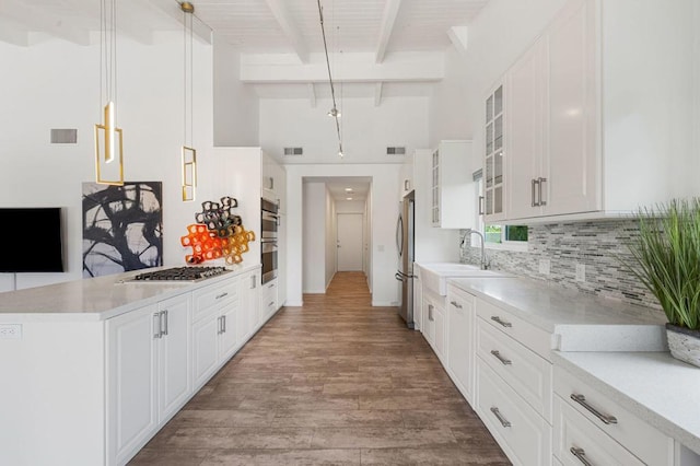 kitchen featuring pendant lighting, white cabinets, and beamed ceiling