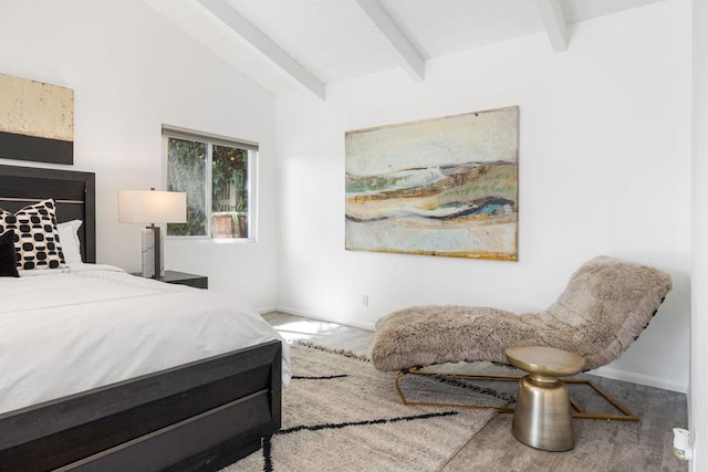 bedroom featuring hardwood / wood-style floors and vaulted ceiling with beams