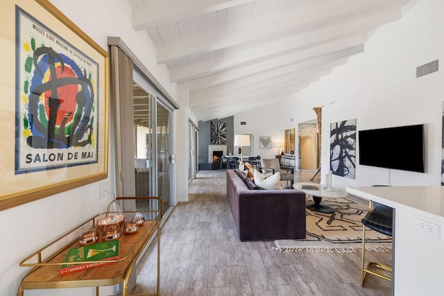 living room with wood-type flooring and vaulted ceiling with beams