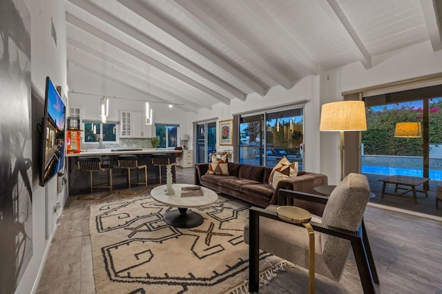 living room featuring lofted ceiling with beams, sink, and light hardwood / wood-style flooring